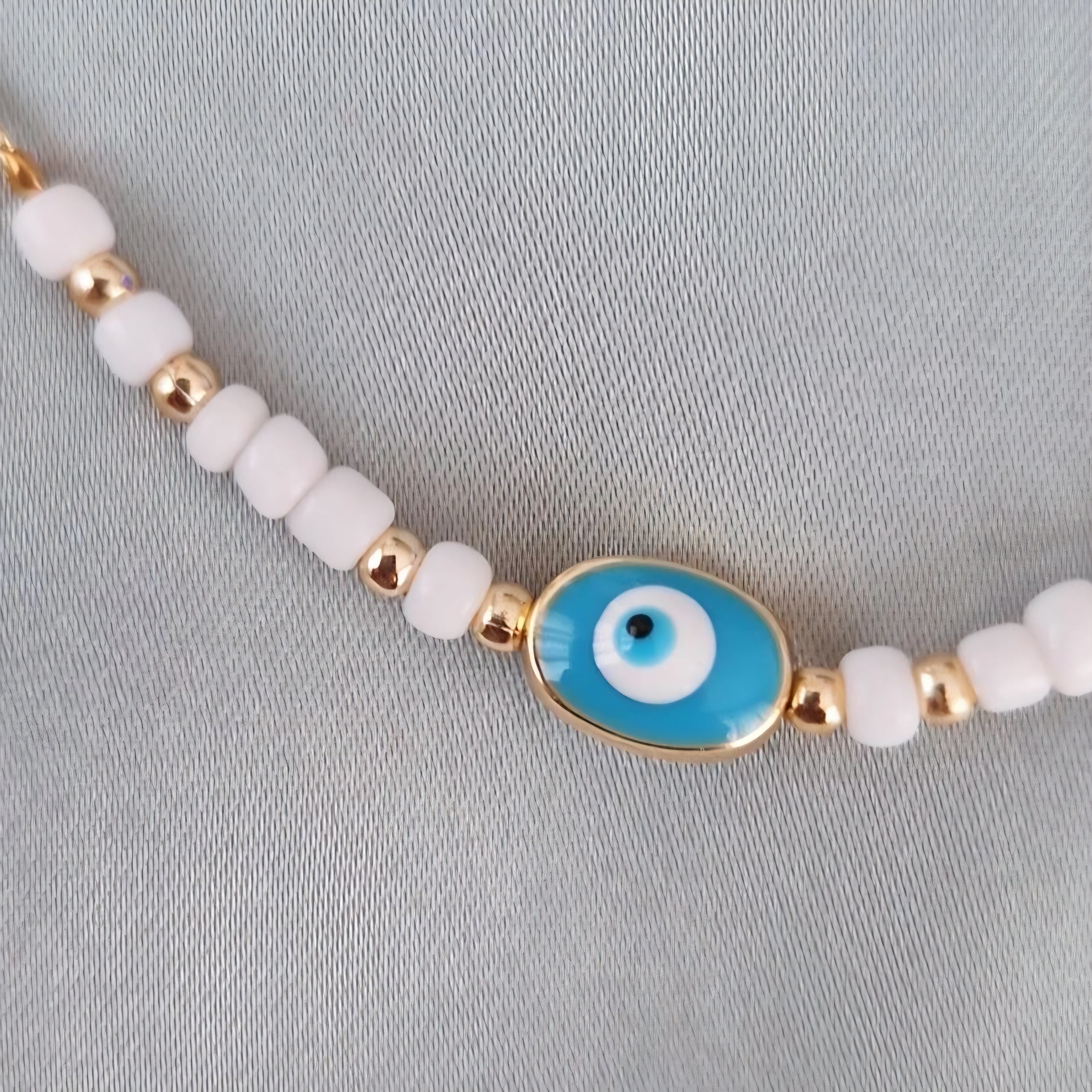 Bracelet fantaisie perles blanches et dorées œil